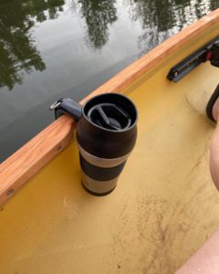 travel mug hanging from side of canoe